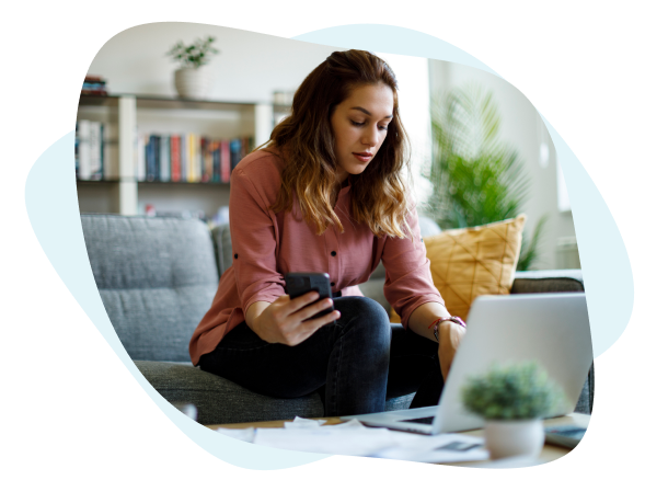 Woman checking phone and laptop